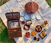 A blanket spread with delicious food, all served in reusable containers to be eco-friendly.