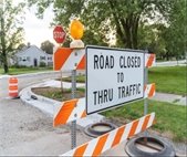 A photo of a sign that says "Road Closed to Thru Traffic" to alert residents to a road closing coming up in July.