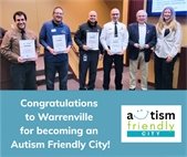 Representatives from the library, park district, fire district, police department, and mayor receiving an Autism Friendly City certificate.