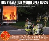 A photo of firefighters during a fire safety demo at the Fire District Open House.