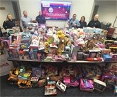 A photo of police personnel surrounded by donated toys for Toys for Tots.